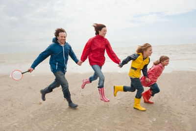 Family holding hands and running on the beach