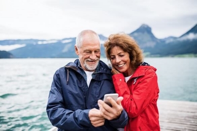 Couple using their phone on the beach.